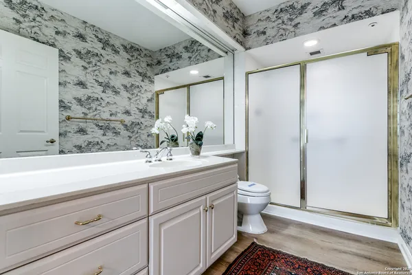 a bathroom with a sink a toilet and shower