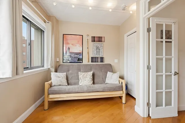a living room with stainless steel appliances kitchen island granite countertop furniture and a wooden floor