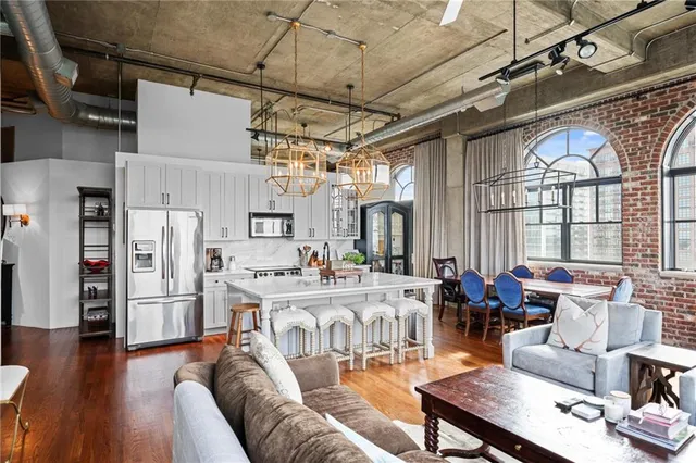 a view of a livingroom with furniture a dinning room and wooden floor