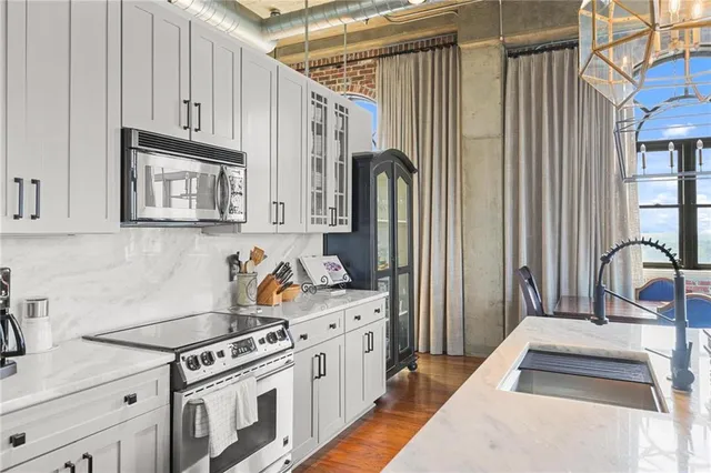 a kitchen with stainless steel appliances granite countertop a stove a sink and a refrigerator