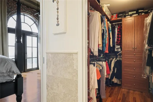 a view of walk in closet with clothes and shoes