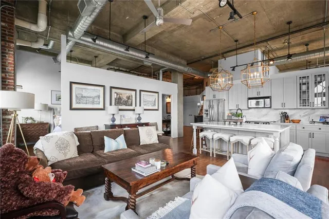 a living room with furniture kitchen view and a chandelier