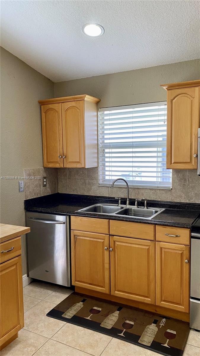 20309 Southwest 86th Court Cutler Bay, FL 33189 - Photo 12 of 59 a kitchen with stainless steel appliances granite countertop a sink stove and cabinets