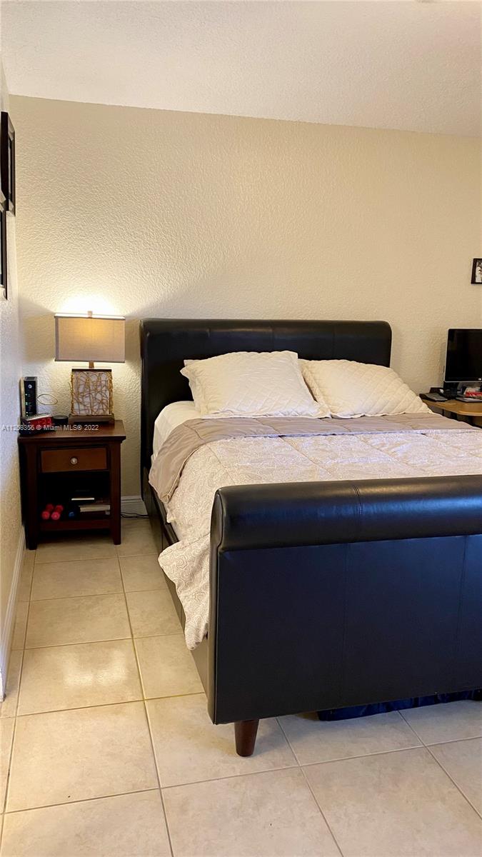 20309 Southwest 86th Court Cutler Bay, FL 33189 - Photo 36 of 59 a bedroom with a bed and a table