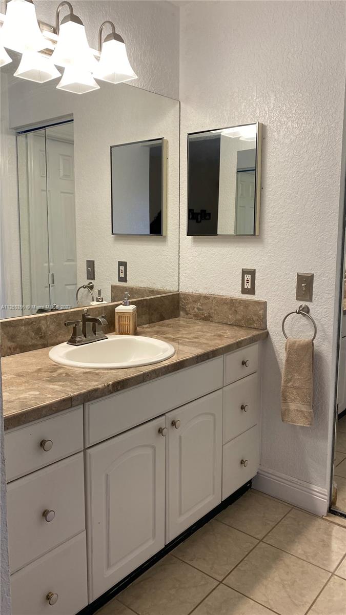 20309 Southwest 86th Court Cutler Bay, FL 33189 - Photo 40 of 59 a bathroom with a double vanity sink and mirror