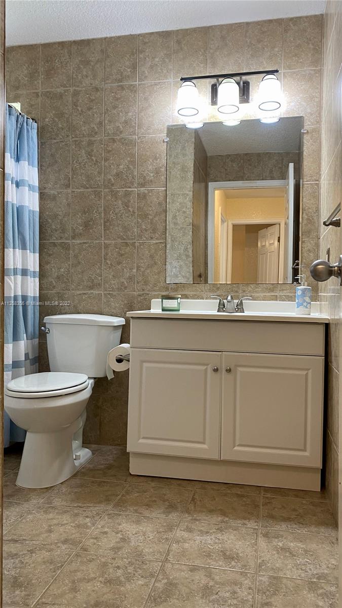 20309 Southwest 86th Court Cutler Bay, FL 33189 - Photo 45 of 59 a bathroom with a toilet a sink and mirror