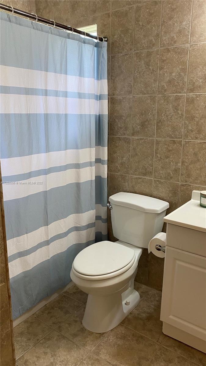 20309 Southwest 86th Court Cutler Bay, FL 33189 - Photo 46 of 59 a white toilet sitting next to a bathroom sink and tub