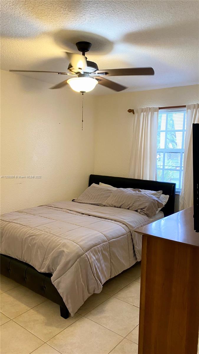 20309 Southwest 86th Court Cutler Bay, FL 33189 - Photo 52 of 59 a bedroom with a bed and a chandelier