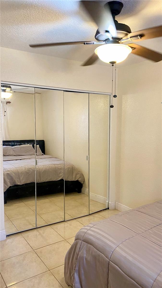 20309 Southwest 86th Court Cutler Bay, FL 33189 - Photo 54 of 59 a bedroom with a bed and a ceiling fan
