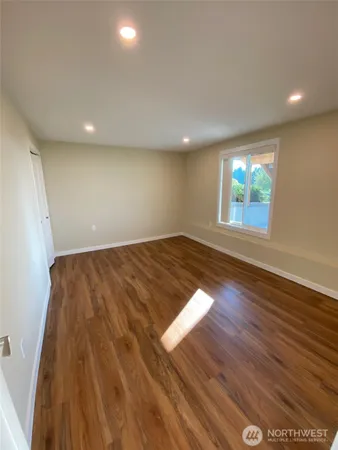 an empty room with wooden floor and fireplace