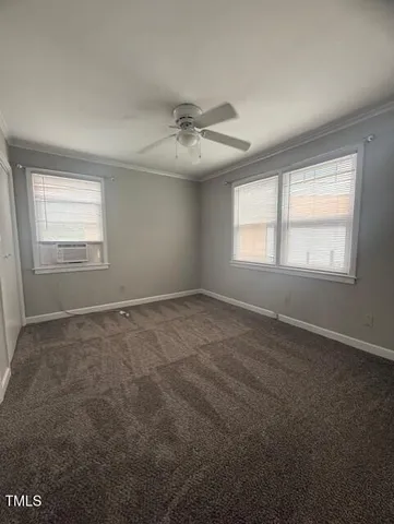 en empty room with windows and ceiling fan