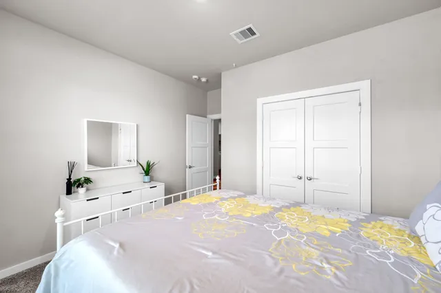 a bedroom with a bed and a potted plant