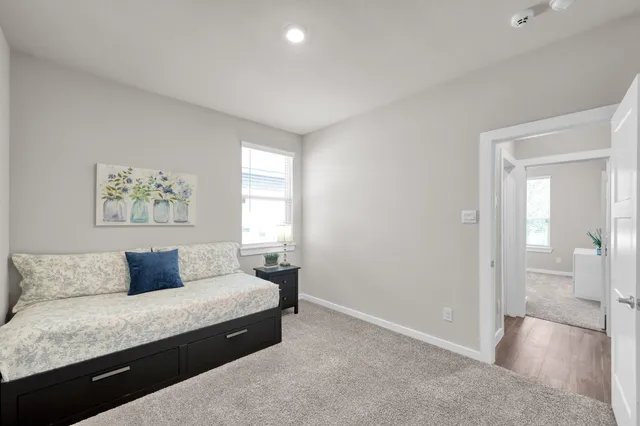 a bedroom with a bed and painting on the wall