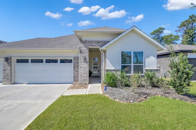 a front view of a house with a garden and yard