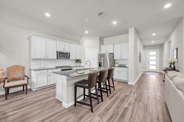 a kitchen with a table chairs refrigerator and cabinets