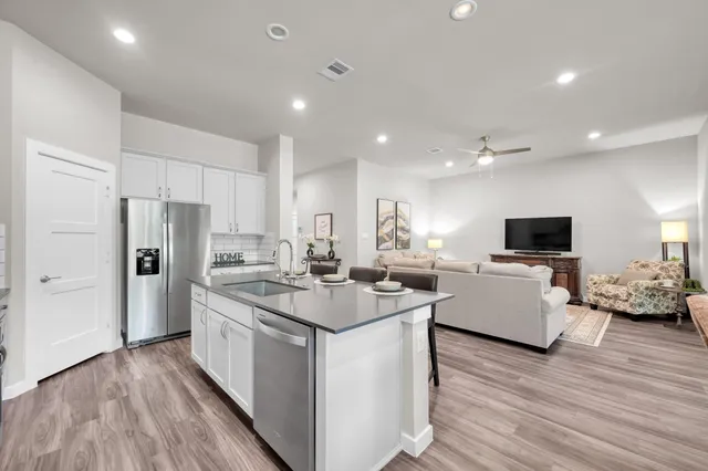a kitchen with stainless steel appliances granite countertop a sink stove and refrigerator