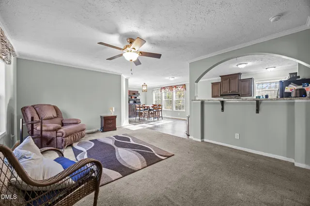 a living room with furniture and kitchen view