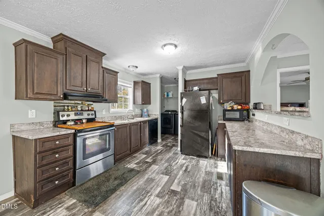 a kitchen with stainless steel appliances granite countertop a refrigerator stove and oven