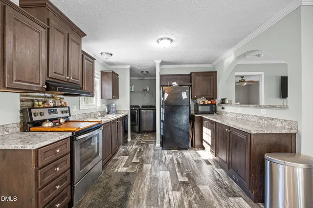 a large kitchen with stainless steel appliances granite countertop a lot of counter space and wooden floor