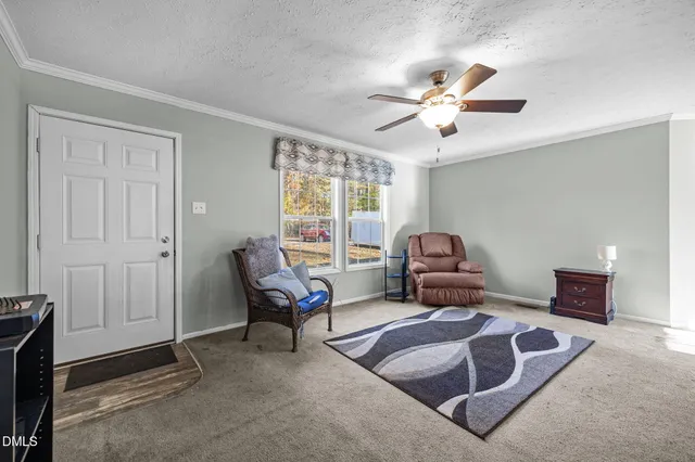 a living room with furniture and a ceiling fan