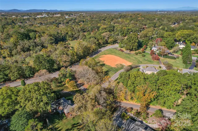 an aerial view of residential house with outdoor space and trees all around