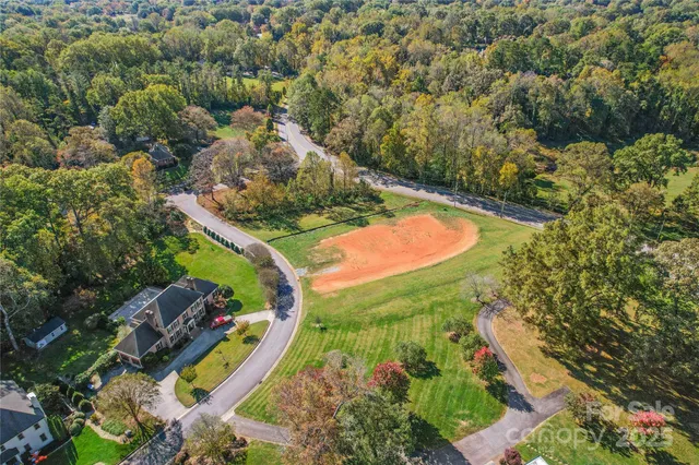an aerial view of residential houses with outdoor space and trees