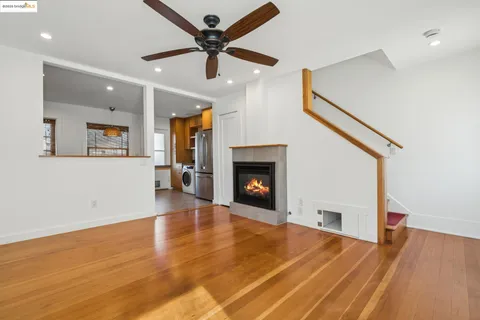 an empty room with wooden floor and fireplace