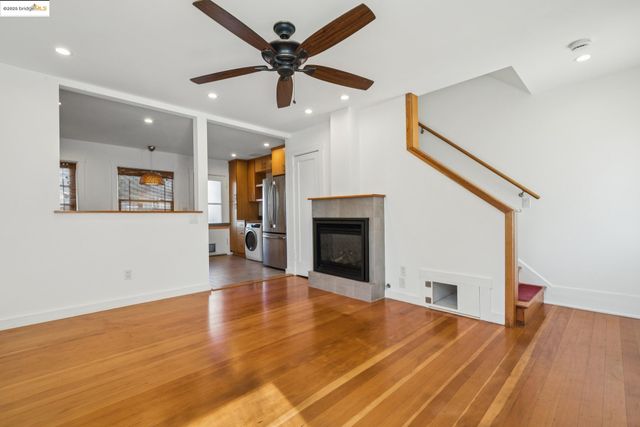 a view of a livingroom with wooden floor and a ceiling fan