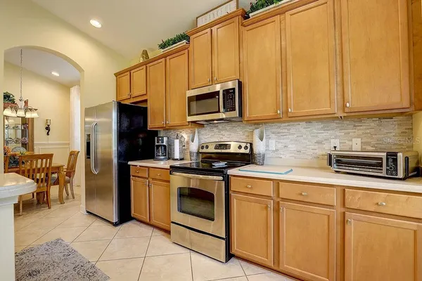 a kitchen with stainless steel appliances granite countertop a sink and a refrigerator