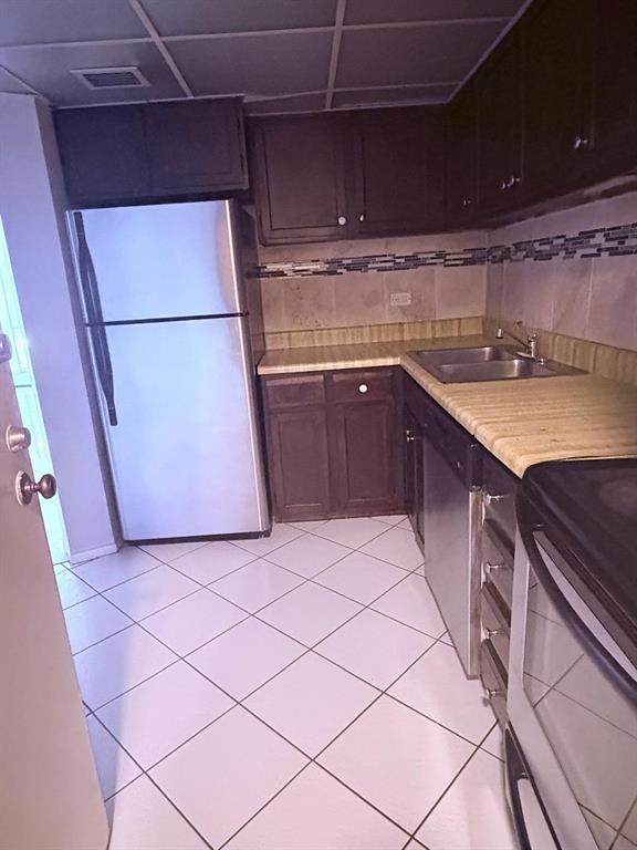 3760 Inverrary Drive, Unit 2H Lauderhill, FL 33319 - Photo 21 of 23 a kitchen with a sink a stove top oven and cabinets