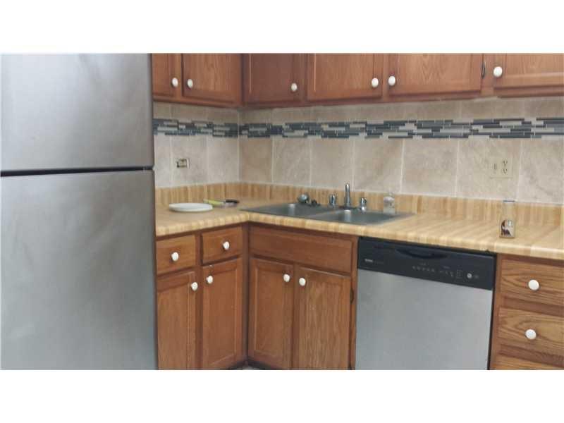 3760 Inverrary Drive, Unit 2H Lauderhill, FL 33319 - Photo 7 of 23 a kitchen with a sink window and cabinets