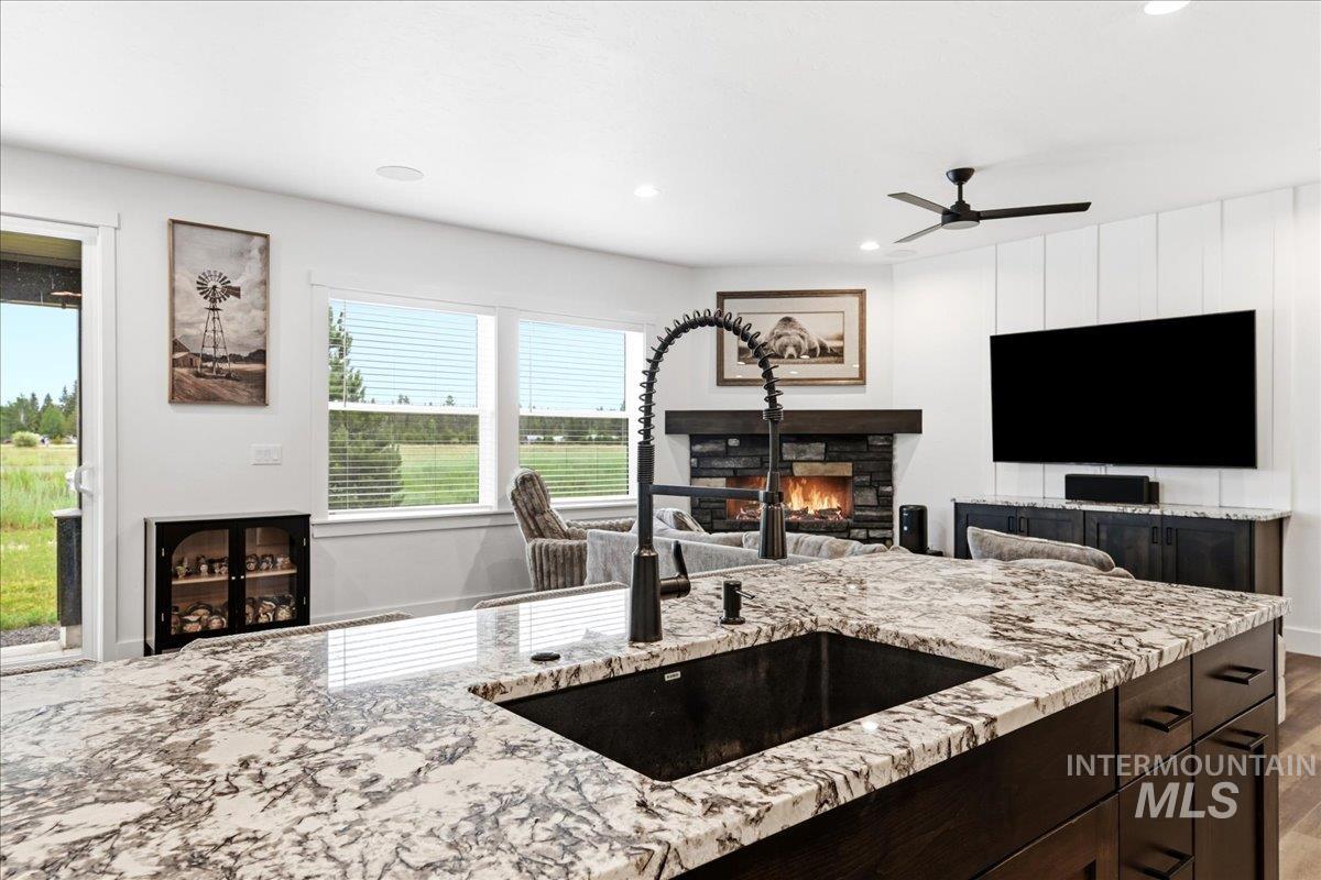 13152 Hawks Bay Road Donnelly, ID 83615 - Photo 9 of 29 Kitchen island with a black composite sink, spring neck faucet, and stone countertop