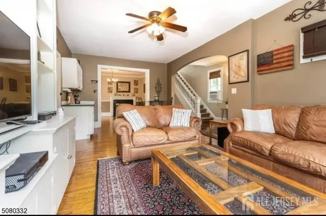 a living room with furniture ceiling fan and a rug