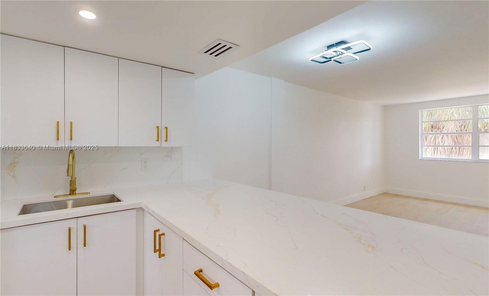 a kitchen with a white cabinets and chandelier