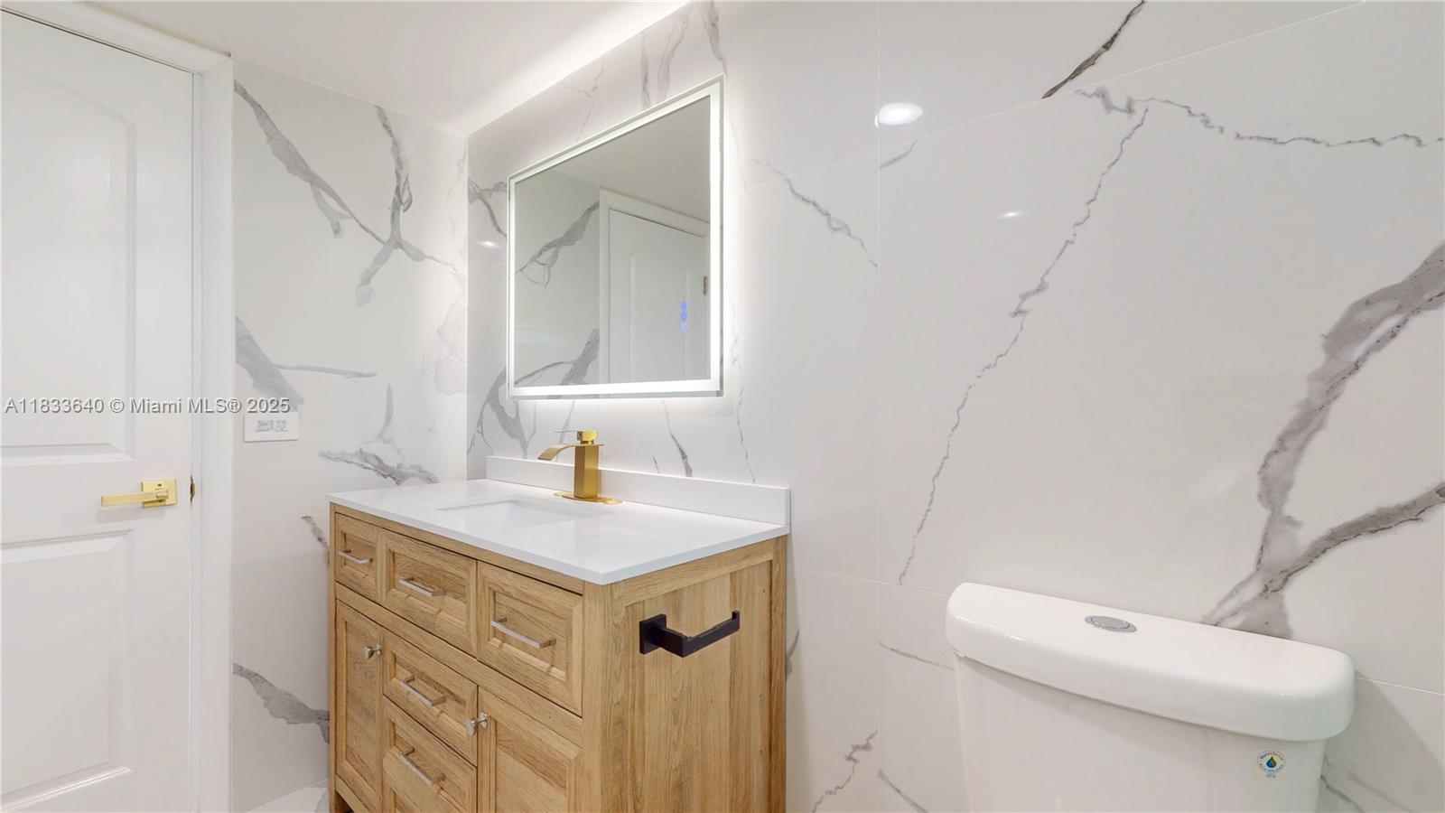 1333 East Hallandale Beach Boulevard, Unit 326 Hallandale Beach, FL 33009 - Photo 24 of 38 a bathroom with a sink a toilet and a mirror