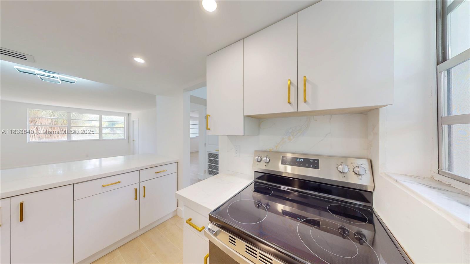 1333 East Hallandale Beach Boulevard, Unit 326 Hallandale Beach, FL 33009 - Photo 28 of 38 a kitchen with white cabinets stove and sink