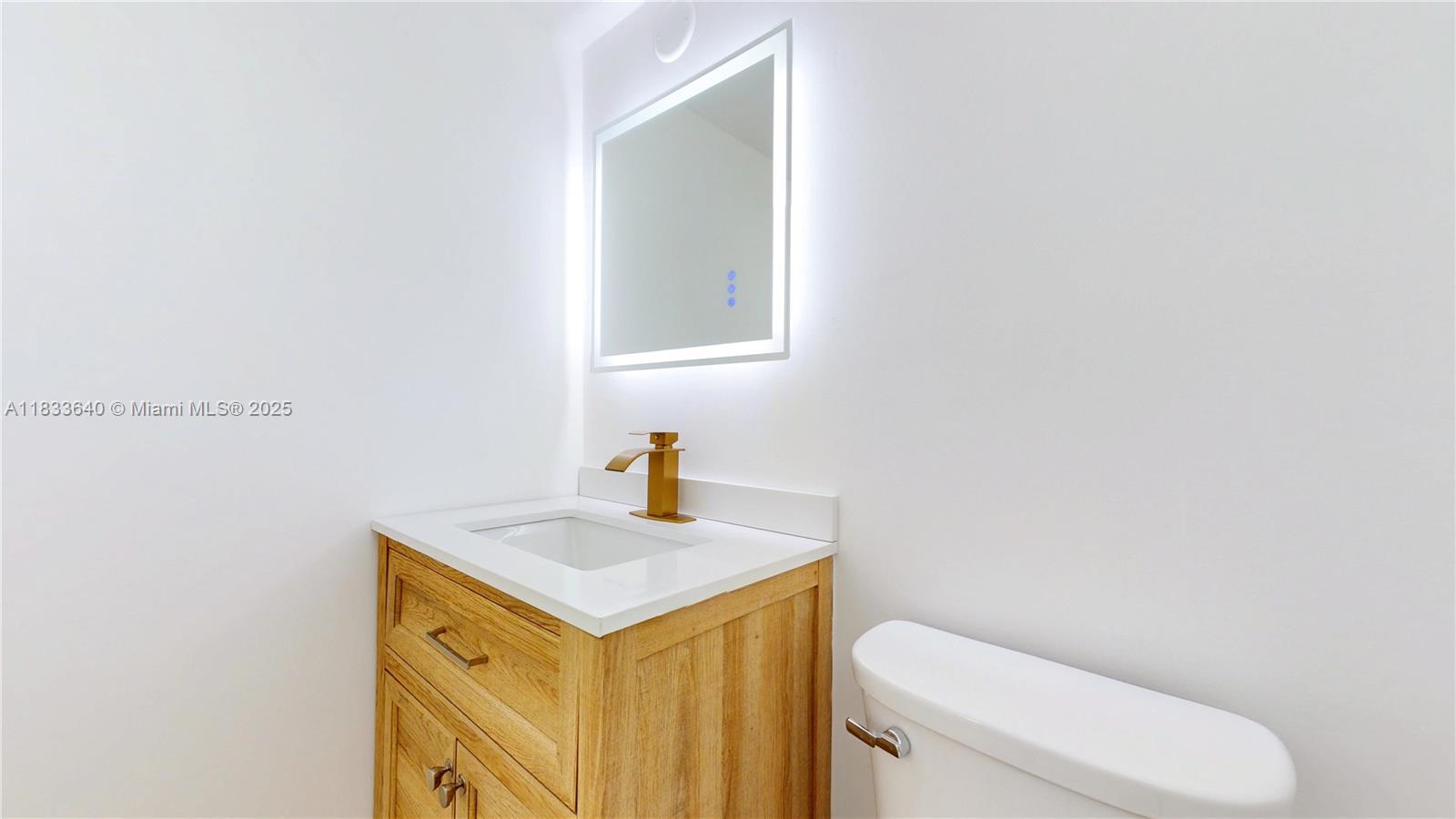 1333 East Hallandale Beach Boulevard, Unit 326 Hallandale Beach, FL 33009 - Photo 30 of 38 a bathroom with a toilet sink and mirror