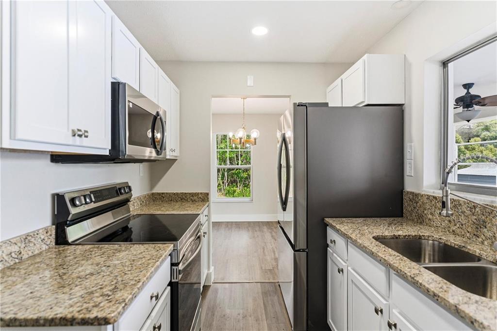 616 Water Road Ocala, FL 34472 - Photo 11 of 32 a kitchen with stainless steel appliances granite countertop a refrigerator a stove a sink and a microwave