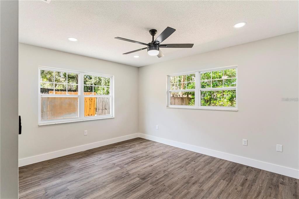 616 Water Road Ocala, FL 34472 - Photo 15 of 32 an empty room with wooden floor ceiling fan and windows