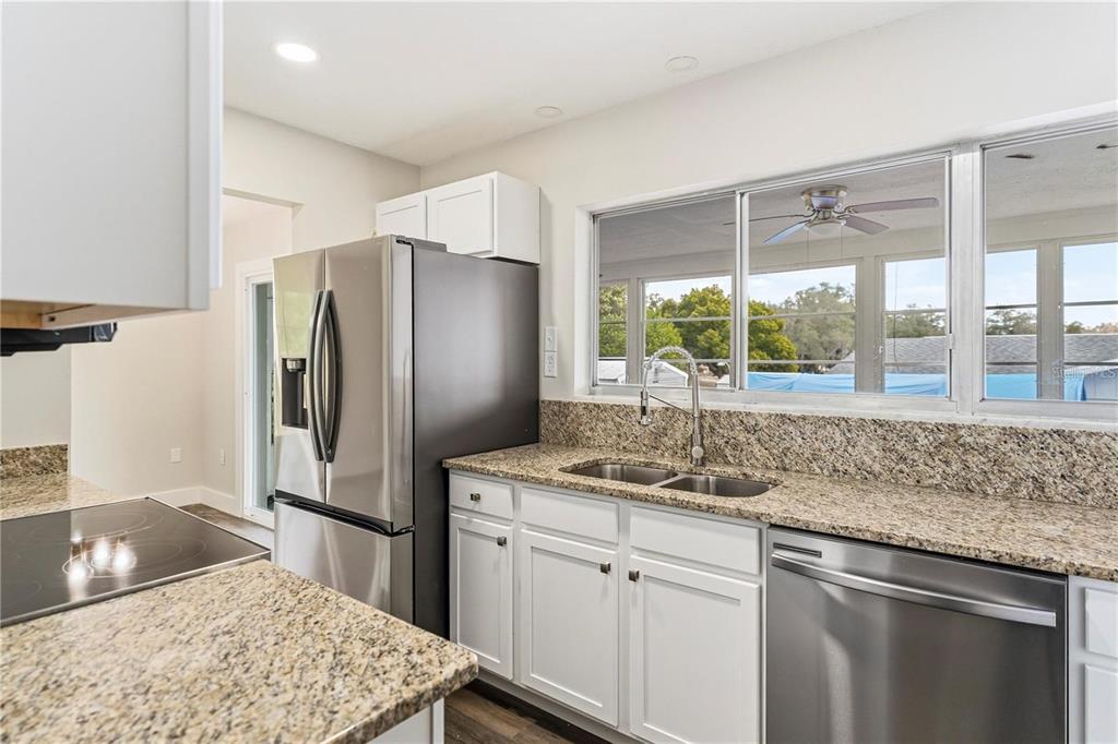 616 Water Road Ocala, FL 34472 - Photo 9 of 32 a kitchen with stainless steel appliances granite countertop a sink stove and refrigerator