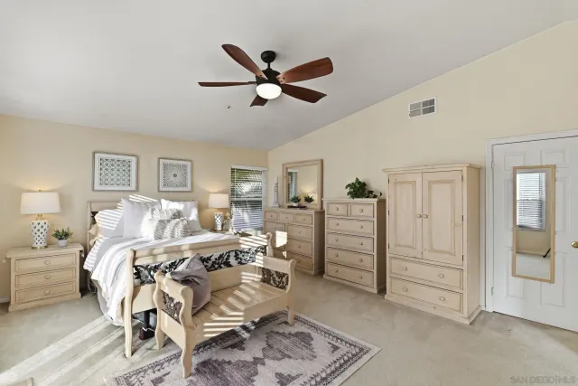 a bed room with a bed and a ceiling fan