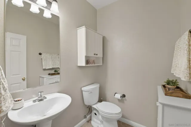 a bathroom with a sink toilet and a mirror