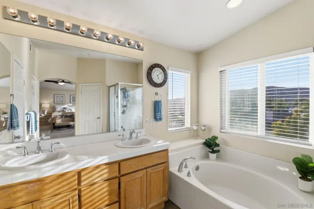 a bathroom with a granite countertop tub and a sink