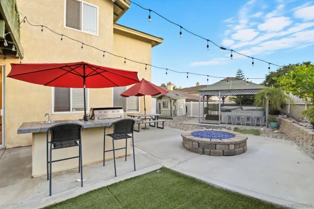 a patio with a table and chairs under an umbrella