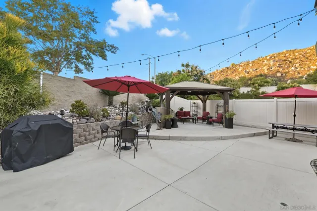 a view of a patio with a table and chairs under an umbrella