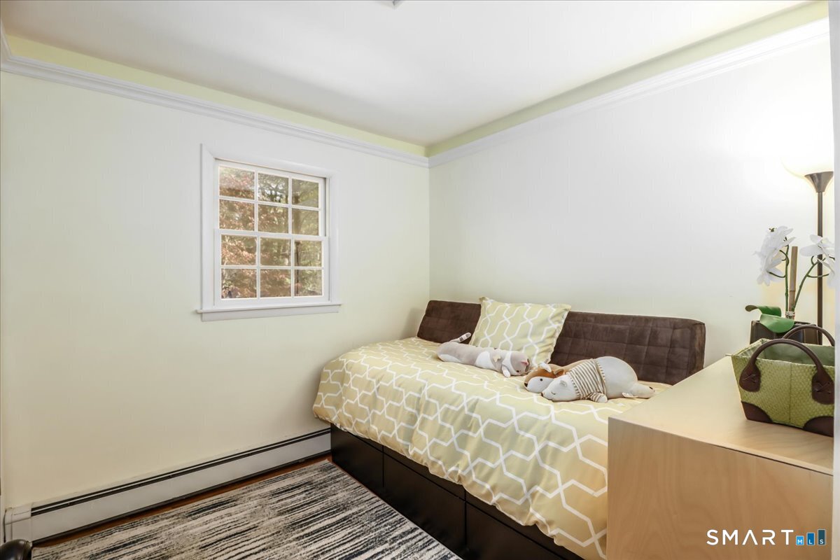 28 Fieldcrest Drive Ridgefield, CT 06877 - Photo 17 of 36 a bed sitting in a bedroom next to a window