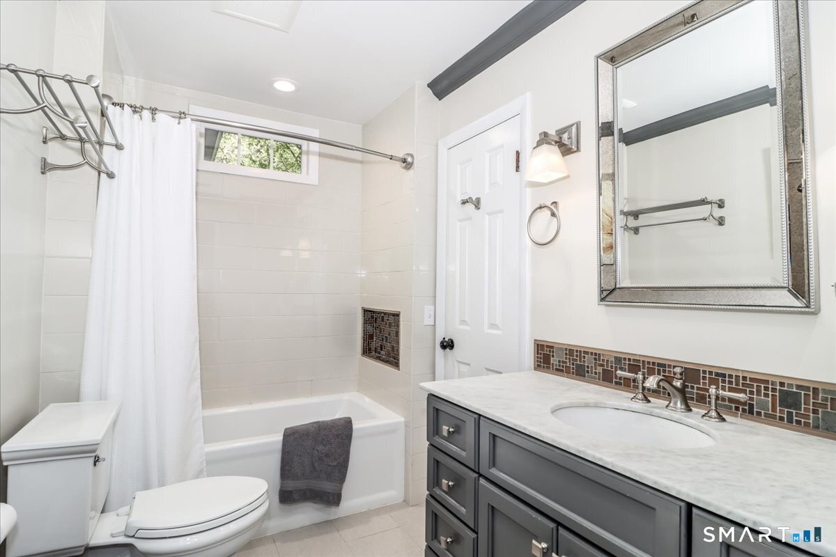 28 Fieldcrest Drive Ridgefield, CT 06877 - Photo 18 of 36 a bathroom with a granite countertop sink toilet a mirror a vanity and shower