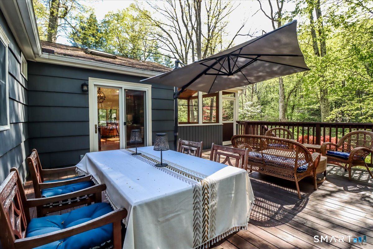 28 Fieldcrest Drive Ridgefield, CT 06877 - Photo 27 of 36 a view of a patio with table and chairs under an umbrella with a barbeque