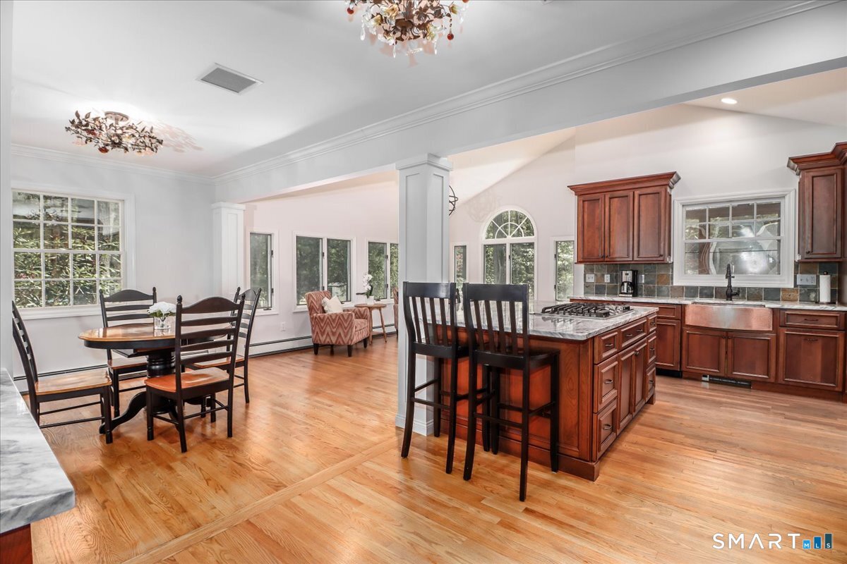 28 Fieldcrest Drive Ridgefield, CT 06877 - Photo 7 of 36 a open kitchen with stainless steel appliances granite countertop a table chairs and a refrigerator