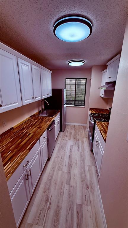 6519 West Newberry Road, Unit 206 Gainesville, FL 32605 - Photo 8 of 14 a kitchen with wooden floors a stove and a microwave
